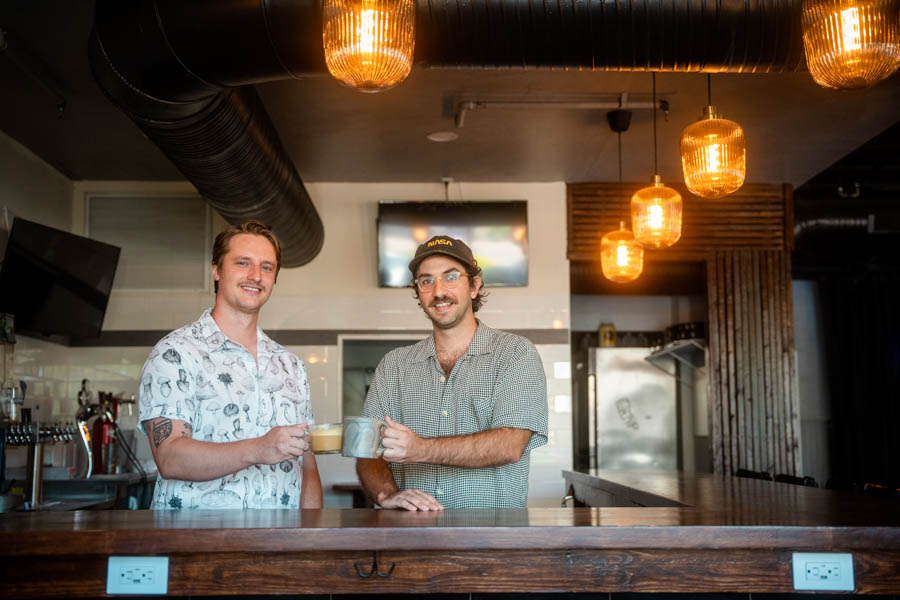 Ben Greene and Keith Nasewicz clink glasses to celebrate Oscura's reimagined new location in downtown Bradenton, replete with a locally sourced menu and beverage program.